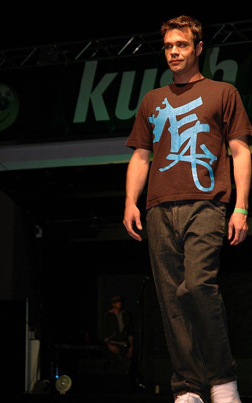 A man wearing a brown shirt with chinese writing on it