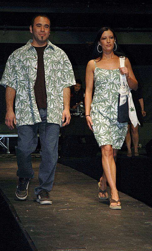 A man and a woman are walking down a runway.