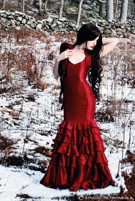 A woman in a red dress is standing in the snow