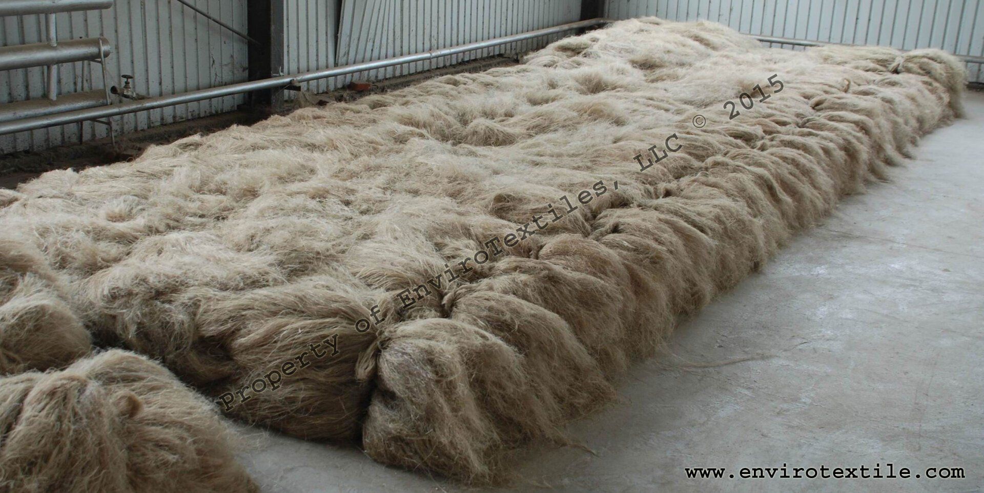 A large pile of wool is sitting on the floor in a room.