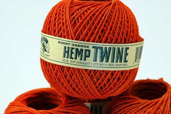 Three balls of orange hemp twine are stacked on top of each other