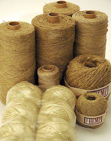 A bunch of spools of yarn are stacked on top of each other on a table.