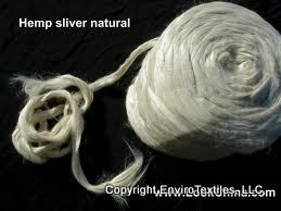 Two balls of hemp sliver natural yarn on a black surface.