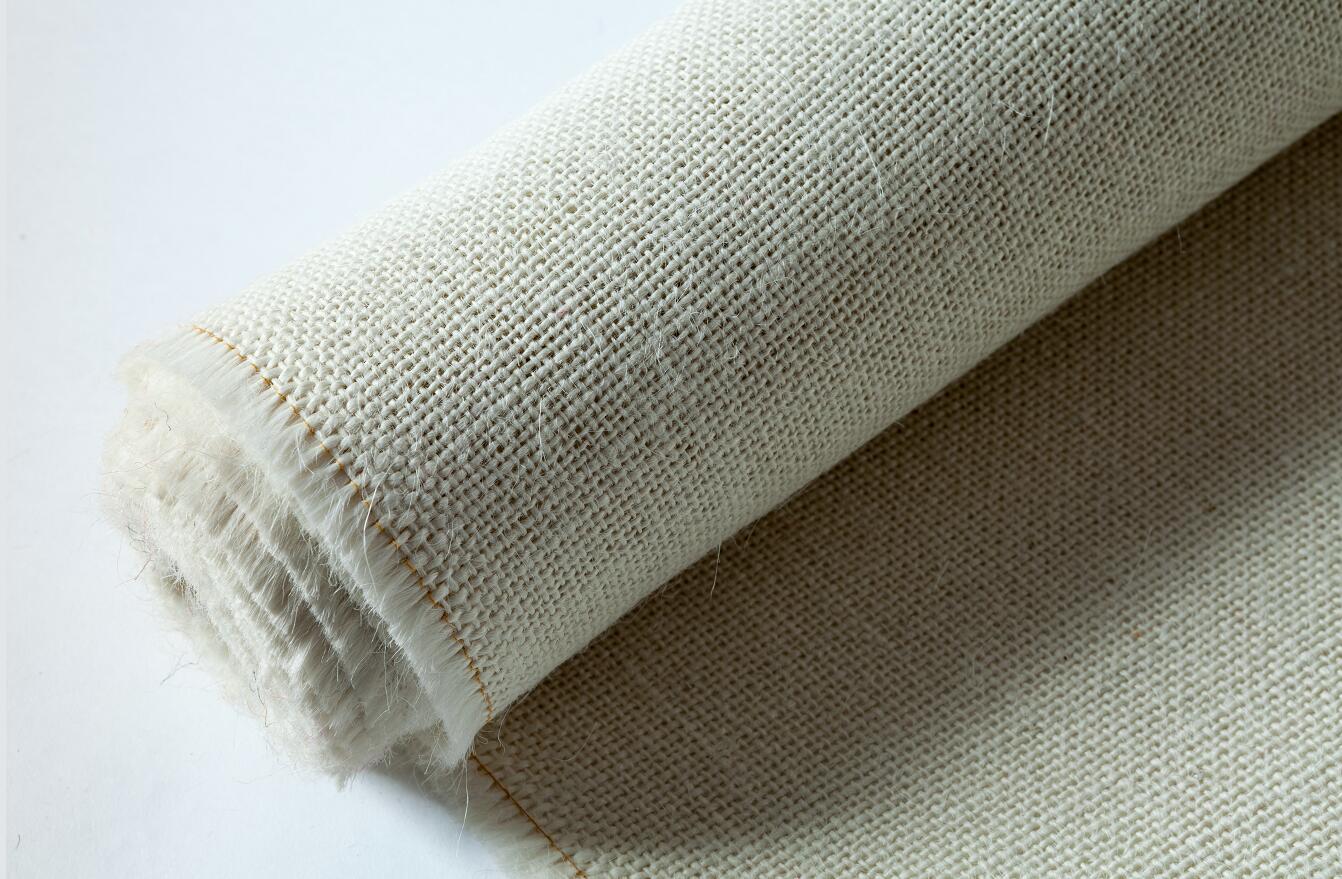 A close up of a roll of fabric on a white surface.