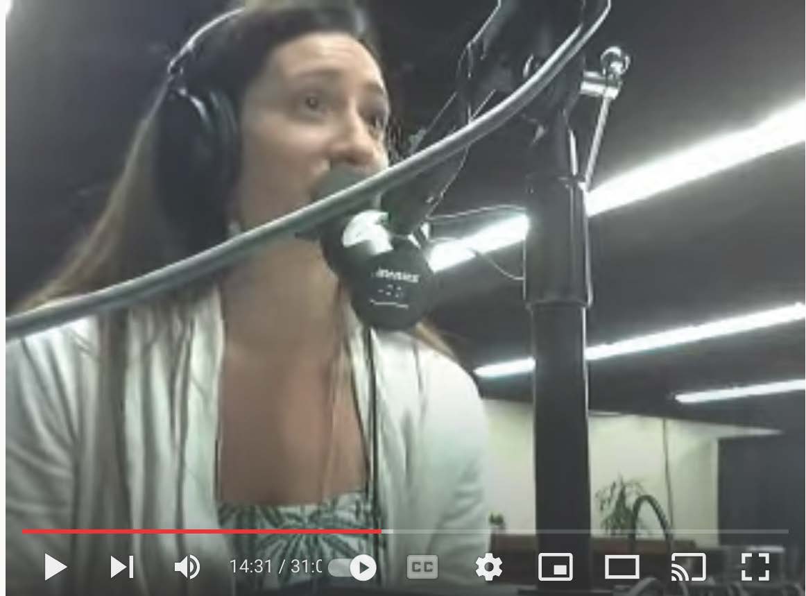 A woman wearing headphones is talking into a microphone.