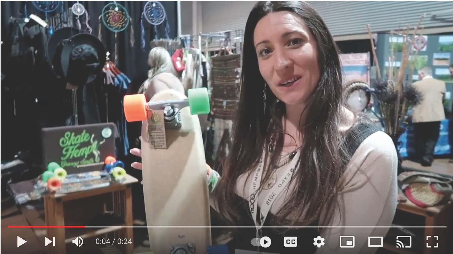 A woman is holding a skateboard in her hands in a video.