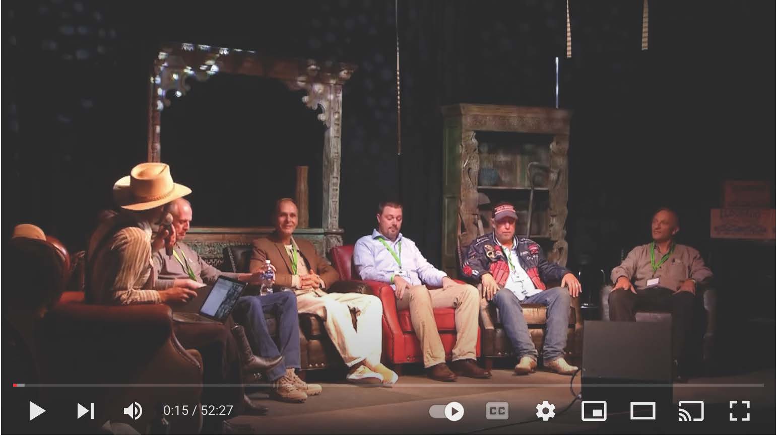 A group of men are sitting in chairs on a stage.