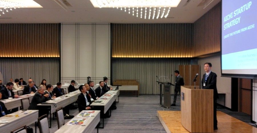 A man is giving a presentation to a group of people in a conference room.