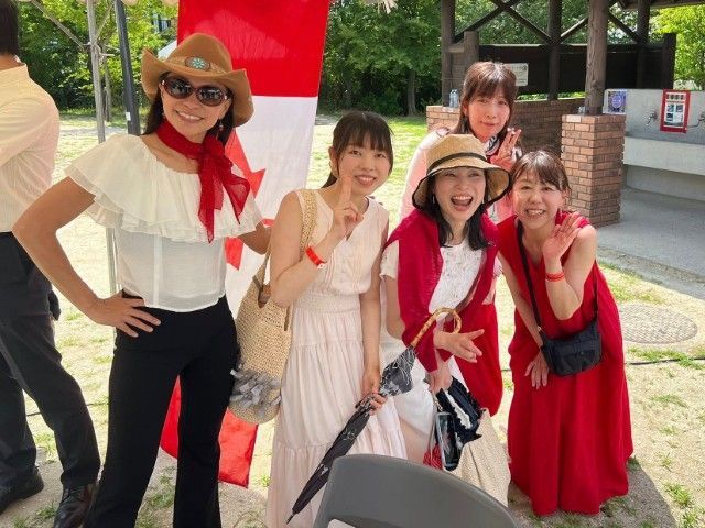 A group of women are posing for a picture in a park.