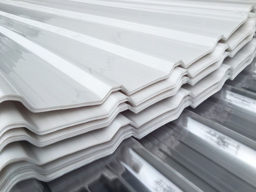 A Close Up of a Stack of White Corrugated Metal Sheets — Rhythm Roofing in Lismore, NSW
