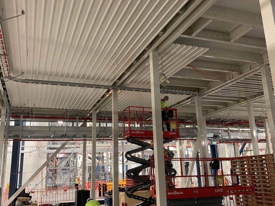 A Group of Construction Workers Are Working on the Ceiling of a Building — Rhythm Roofing in Grafton, NSW