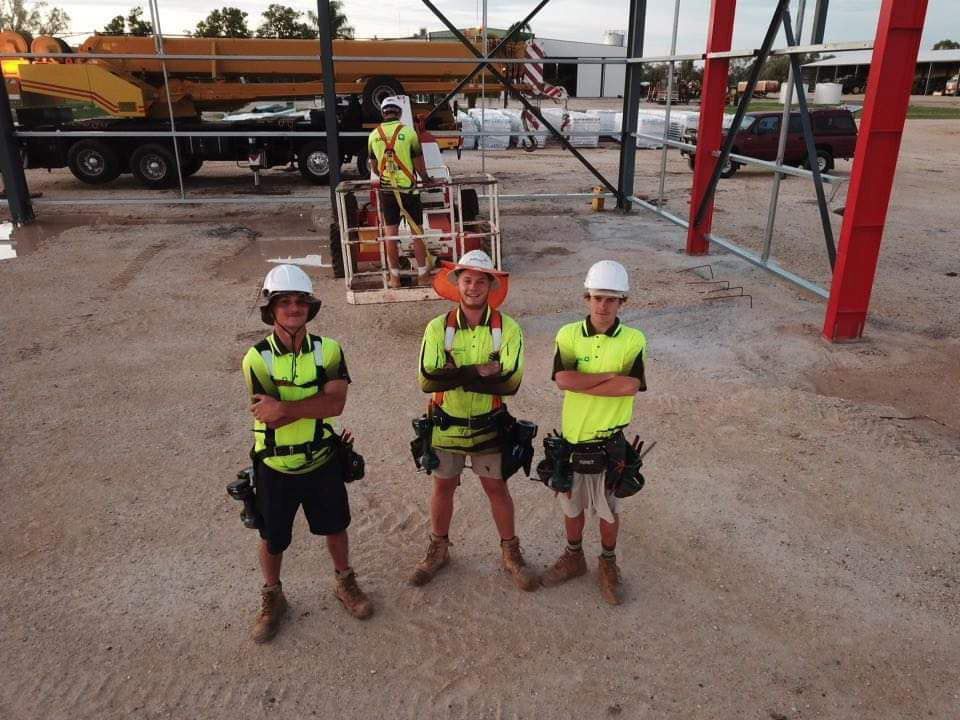 A Group of Construction Workers Are Posing for a Picture — Rhythm Roofing in North Boambee Valley, NSW