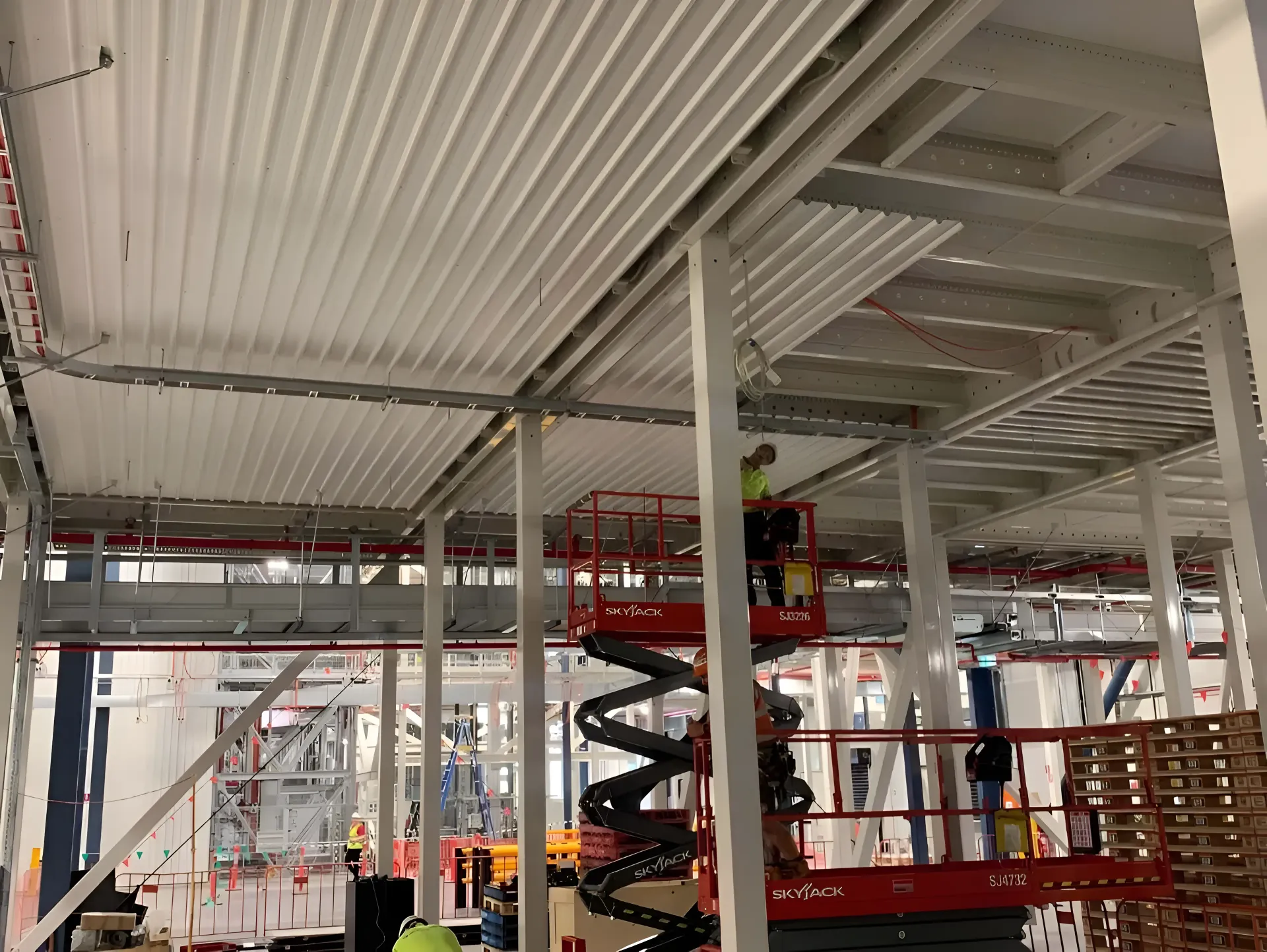 A Group of Construction Workers Are Working on the Ceiling of a Building — Rhythm Roofing in Ballina, NSW