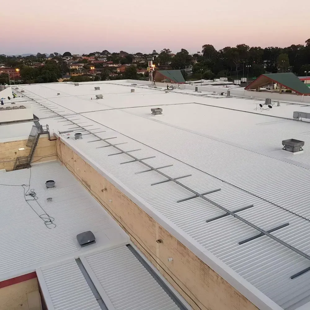 An Aerial View of a Large White Roof — Rhythm Roofing in North Boambee Valley, NSW