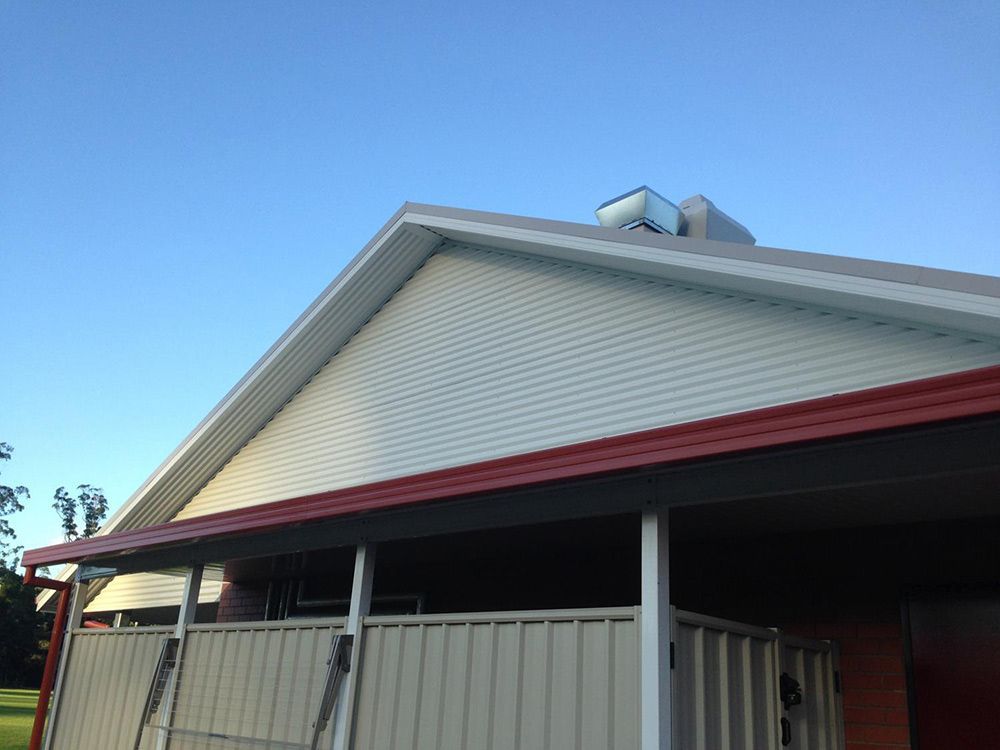 A White House With a Red Roof and a Ladder on the Porch — Rhythm Roofing in North Boambee Valley, NSW