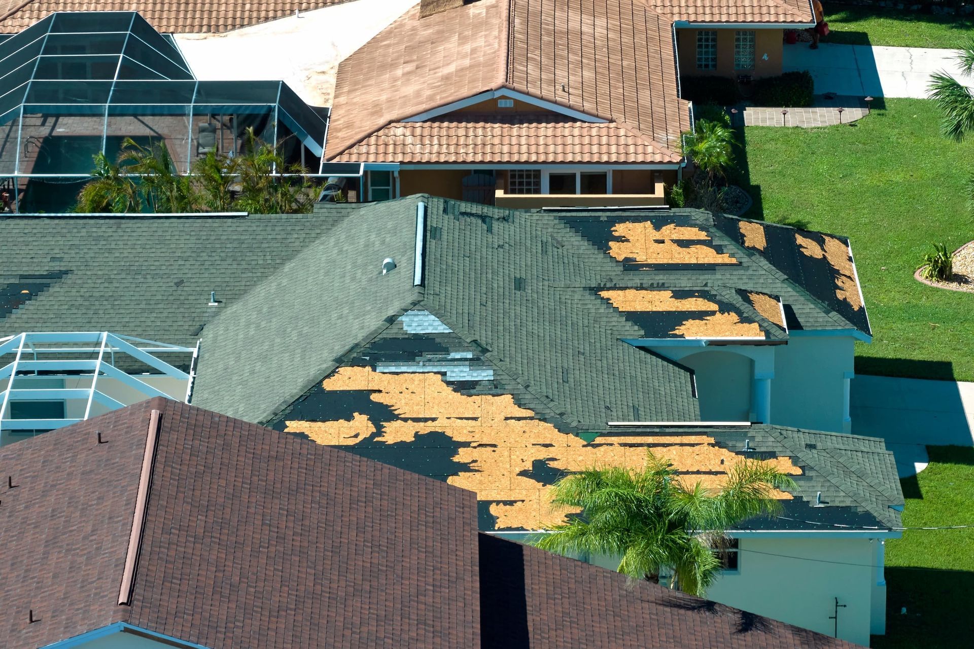 An aerial view of a house with a roof that is missing shingles