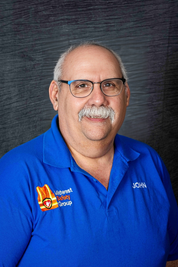 A man with glasses and a mustache is wearing a blue shirt.