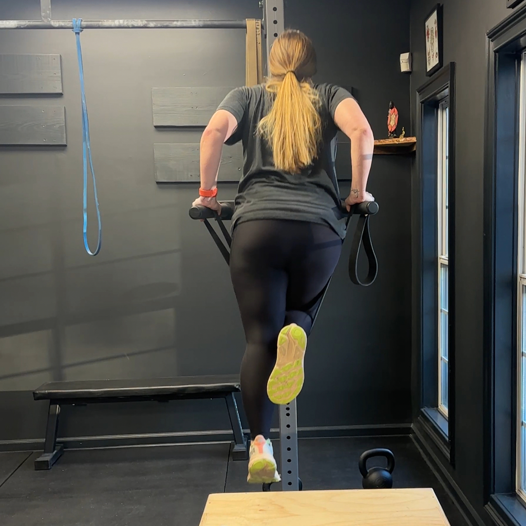 A woman is doing dips in a gym