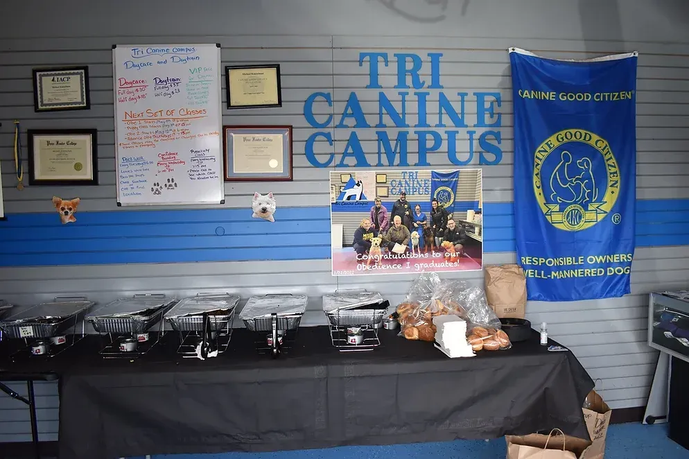 A table with food on it in front of a wall that says tri canine campus