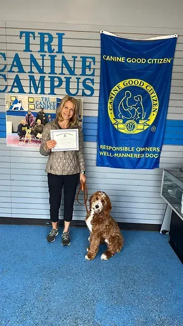 A woman is standing next to a dog and holding a certificate.