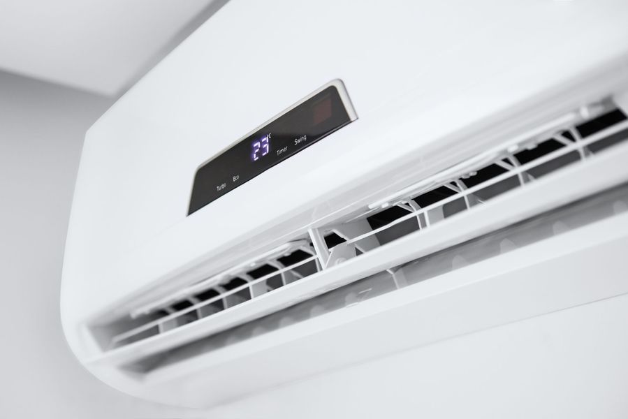 Condizionatore d'aria bianco da parete che indica una temperatura di 23 gradi.