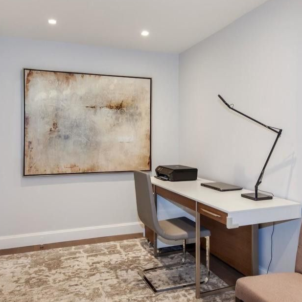 Construction worker holding blueprints at a construction site, wearing a reflective vest.