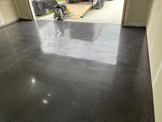 Dark, glossy concrete garage floor with a reflective surface.