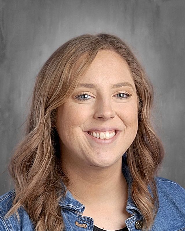 Young man in a blazer and white shirt, with blonde hair and a goatee, looking at the viewer.