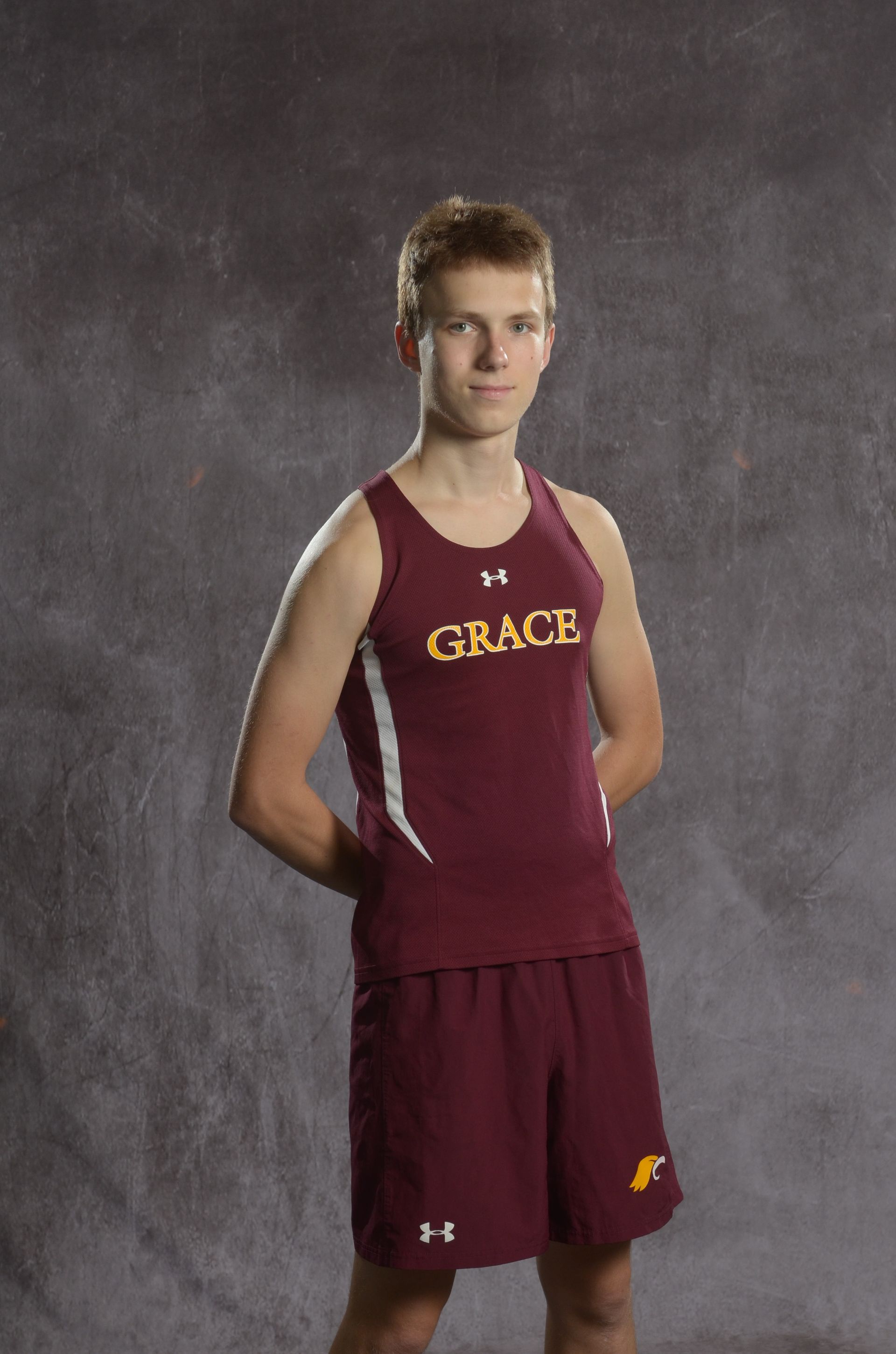 Maroon eagle head with yellow beak, facing right.