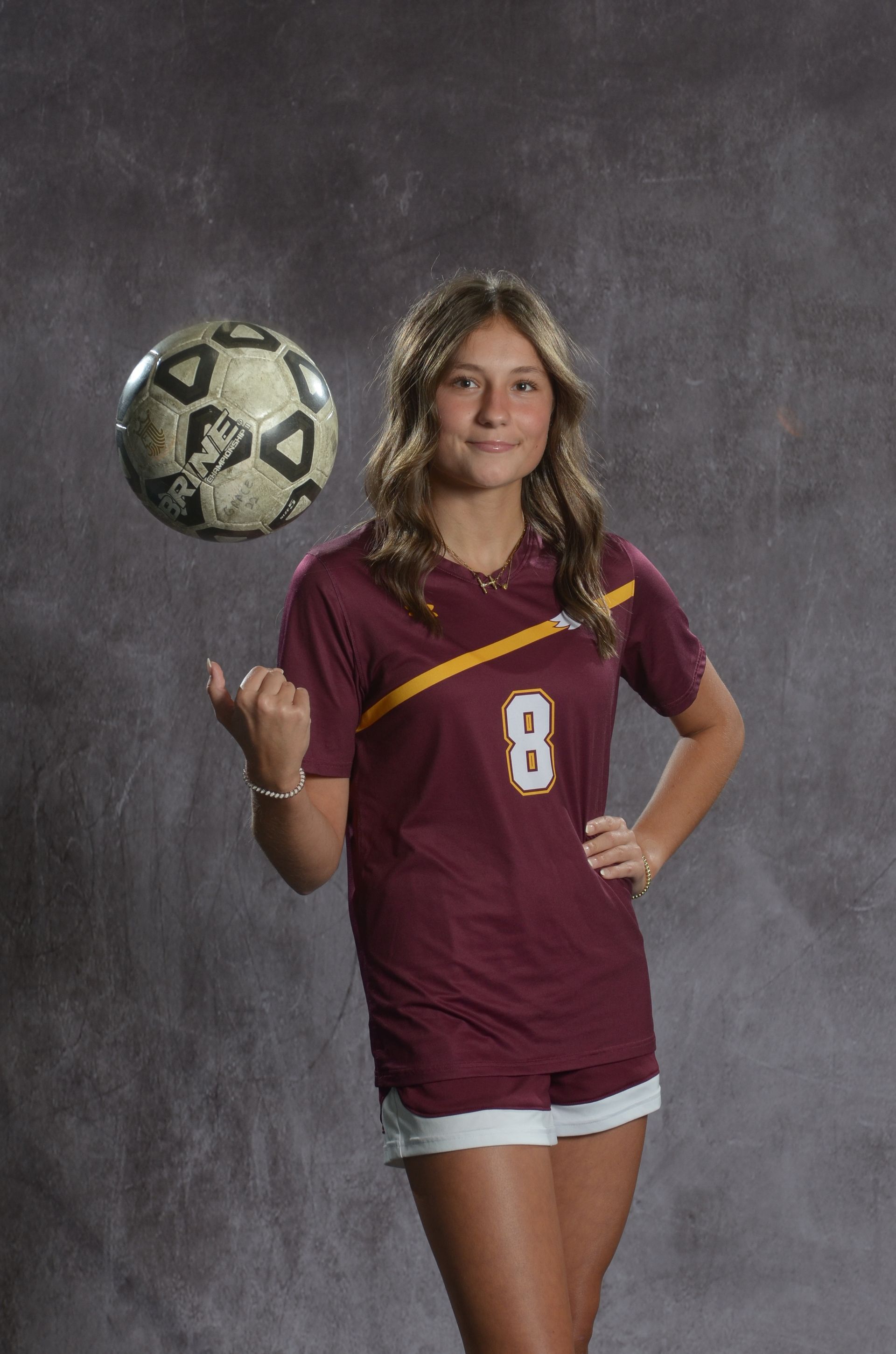Eagle head logo, maroon feathers and yellow beak, facing right.