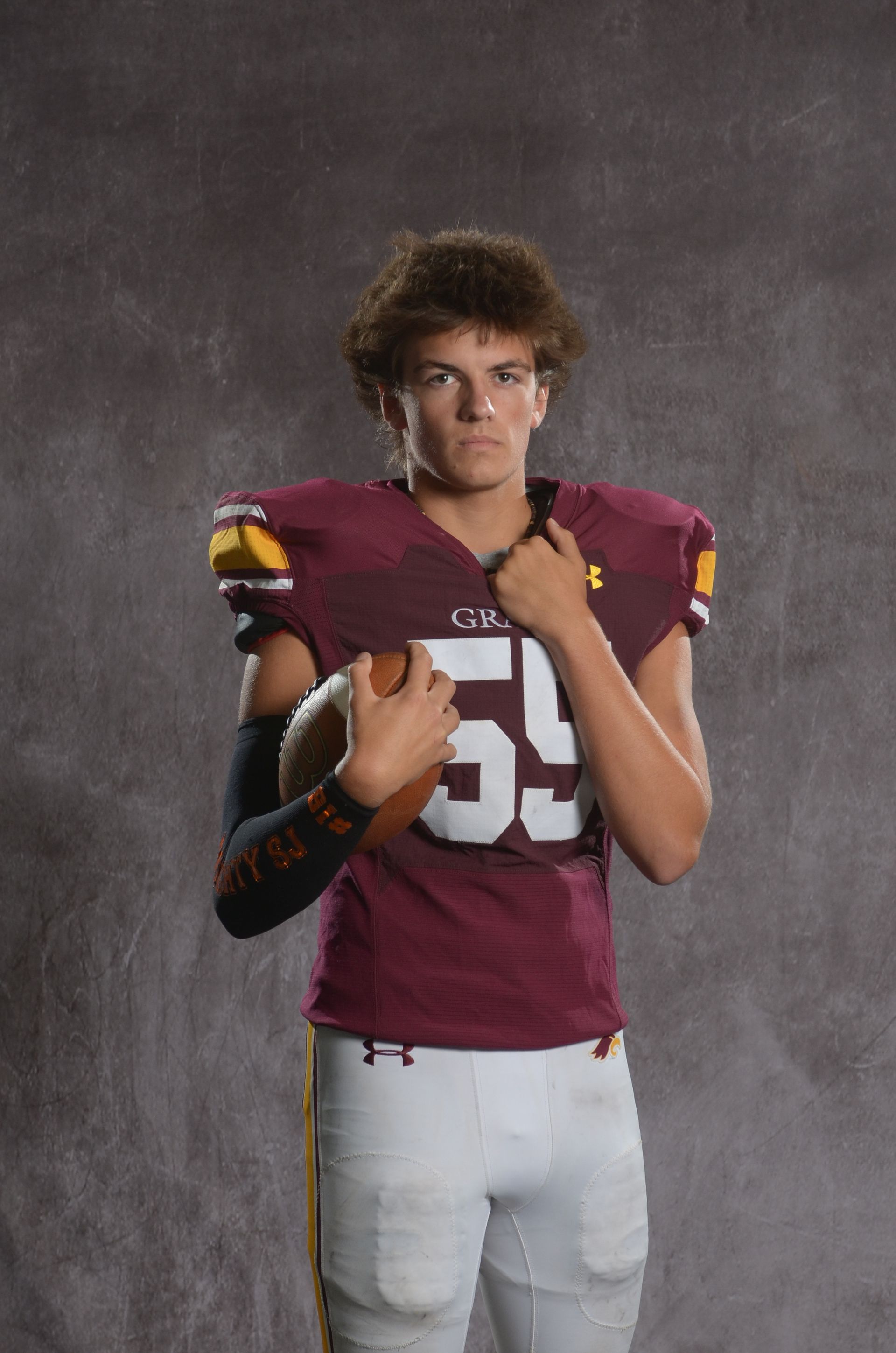 A maroon eagle head logo with a yellow beak on a white background.