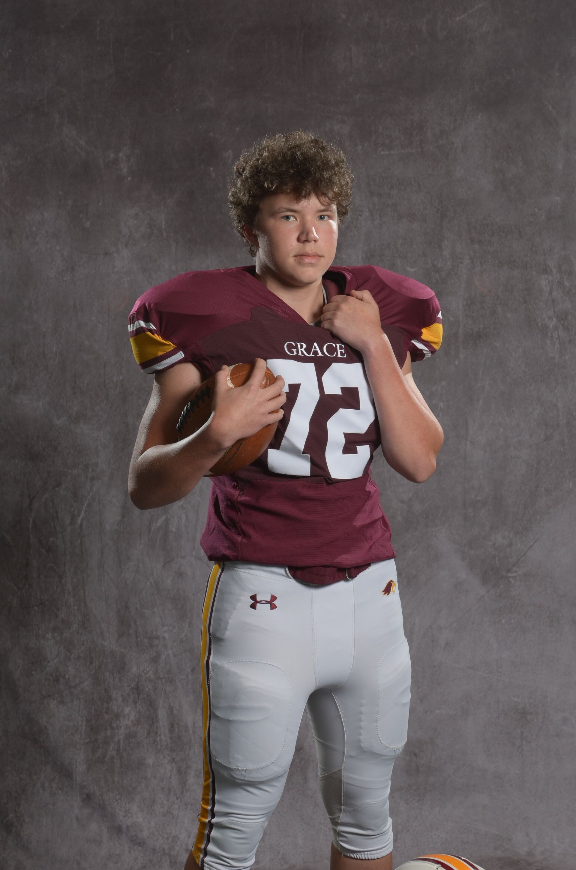 A maroon eagle head logo with a yellow beak on a white background.