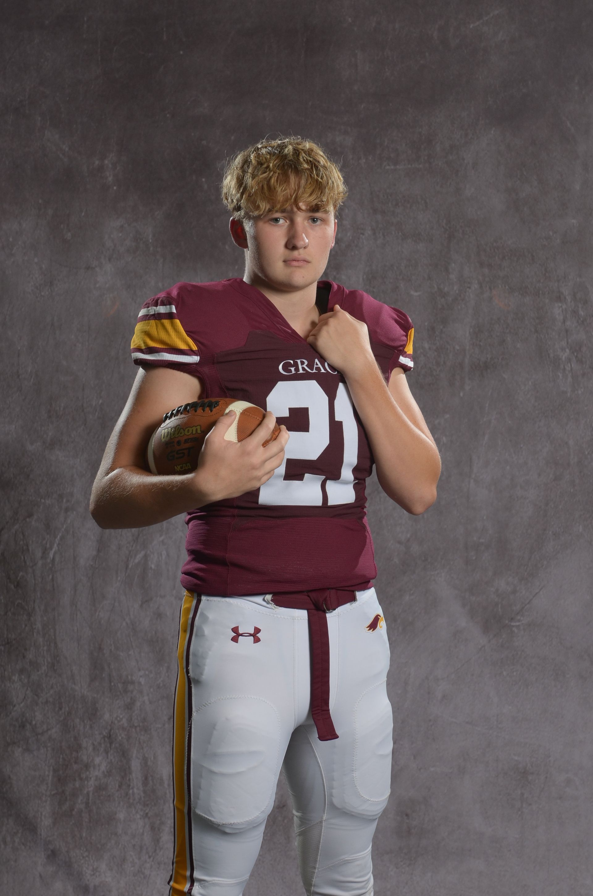 A maroon eagle head logo with a yellow beak on a white background.