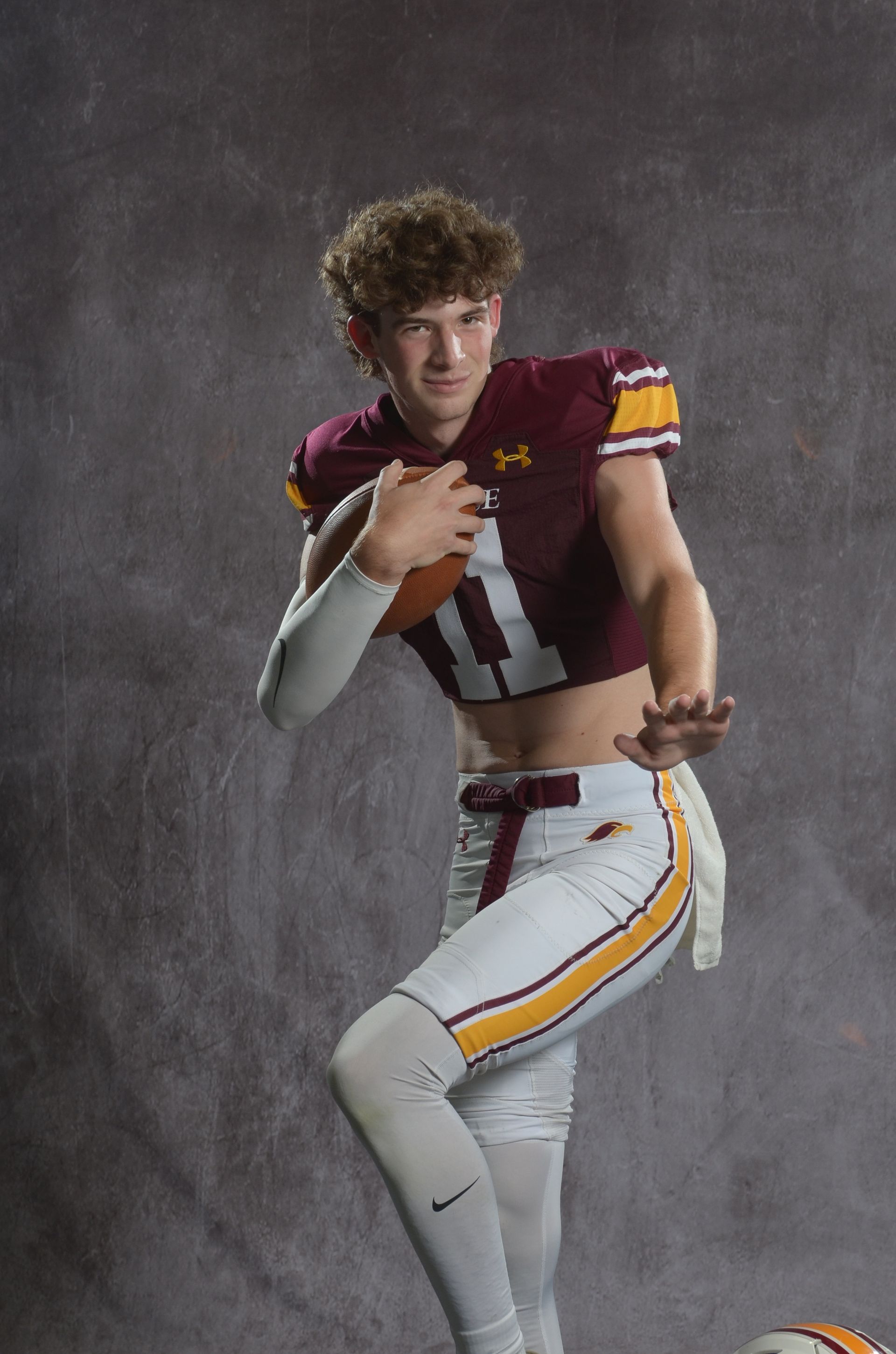 A maroon eagle head logo with a yellow beak on a white background.