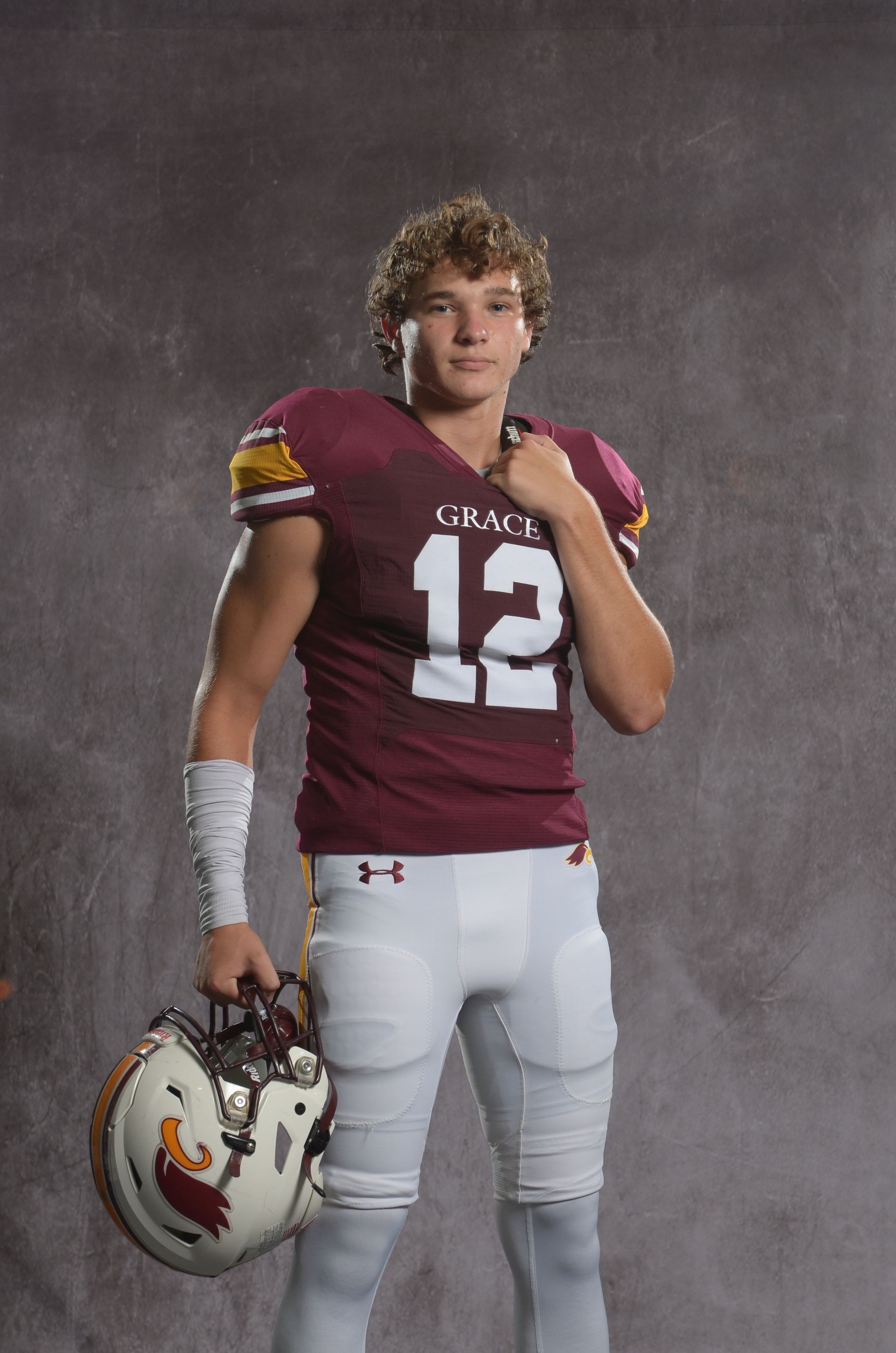 A maroon eagle head logo with a yellow beak on a white background.