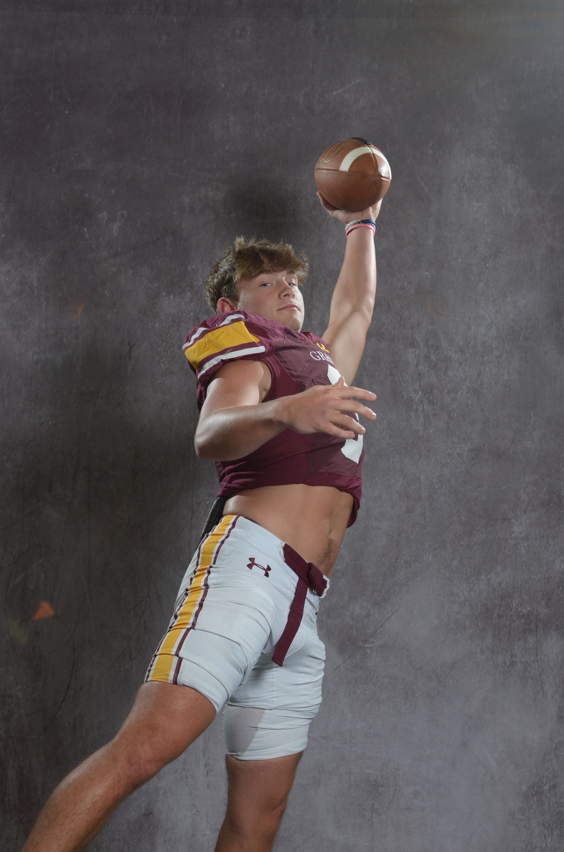 A maroon eagle head logo with a yellow beak on a white background.