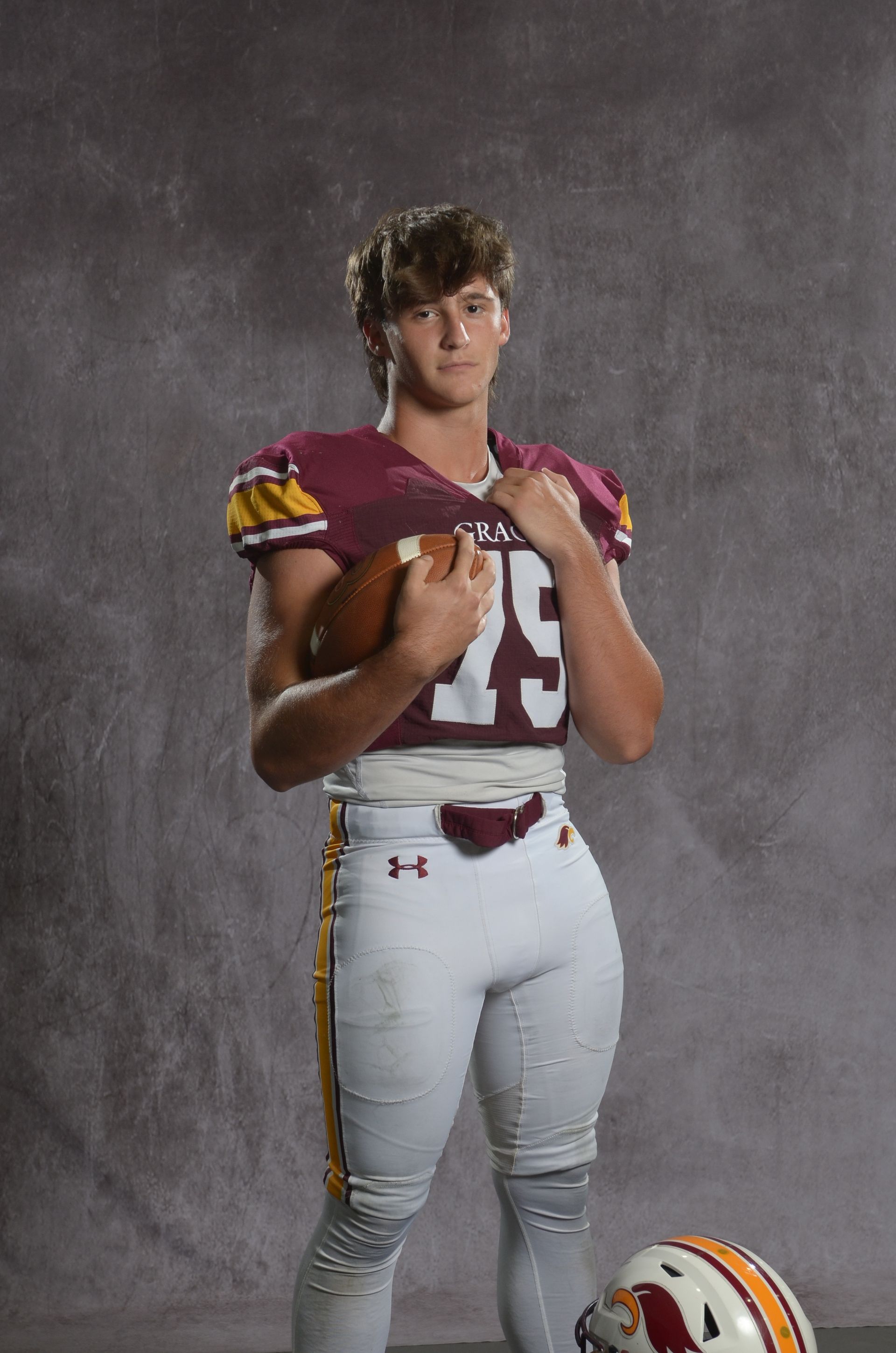 A maroon eagle head logo with a yellow beak on a white background.