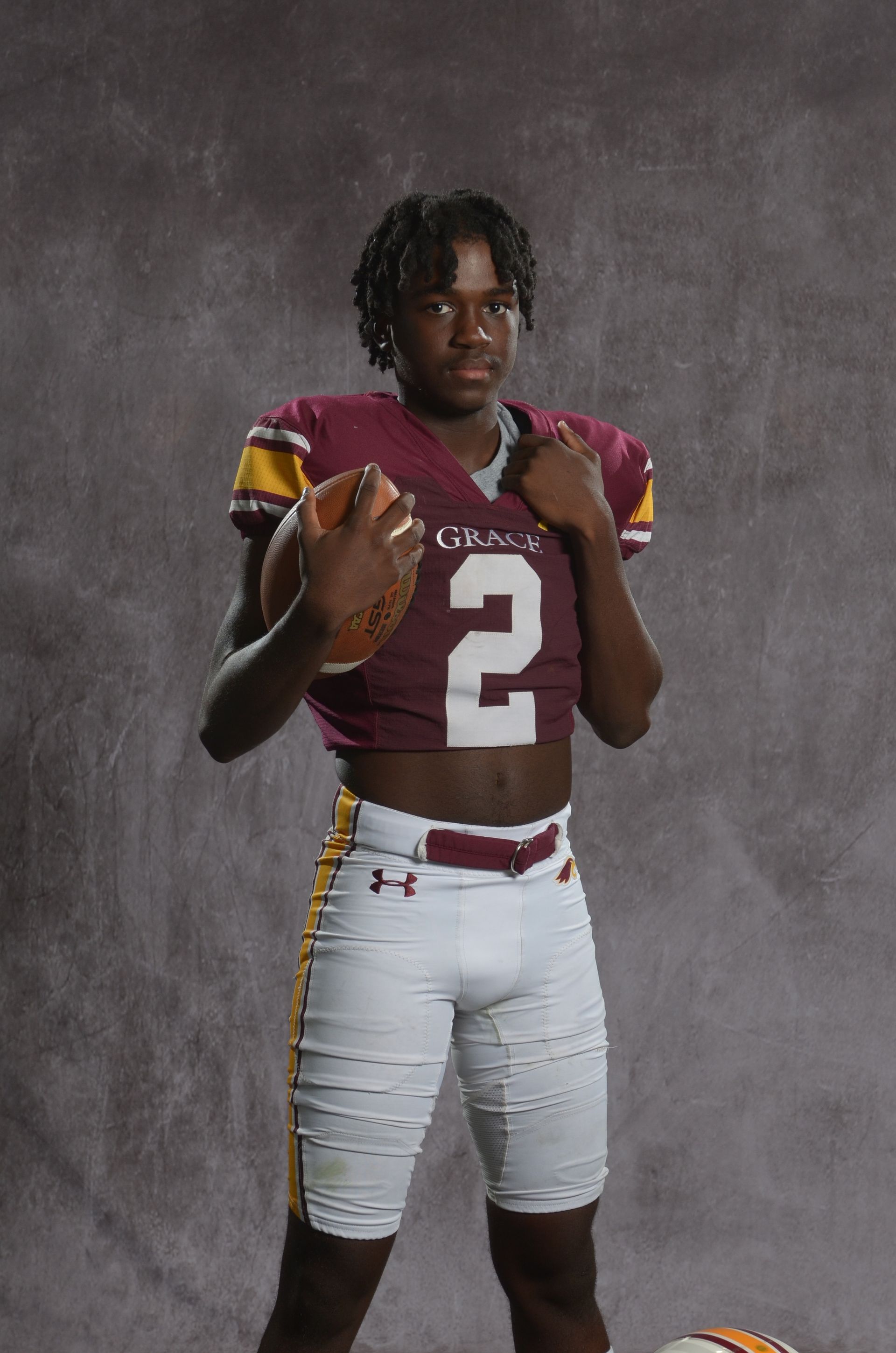 A maroon eagle head logo with a yellow beak on a white background.