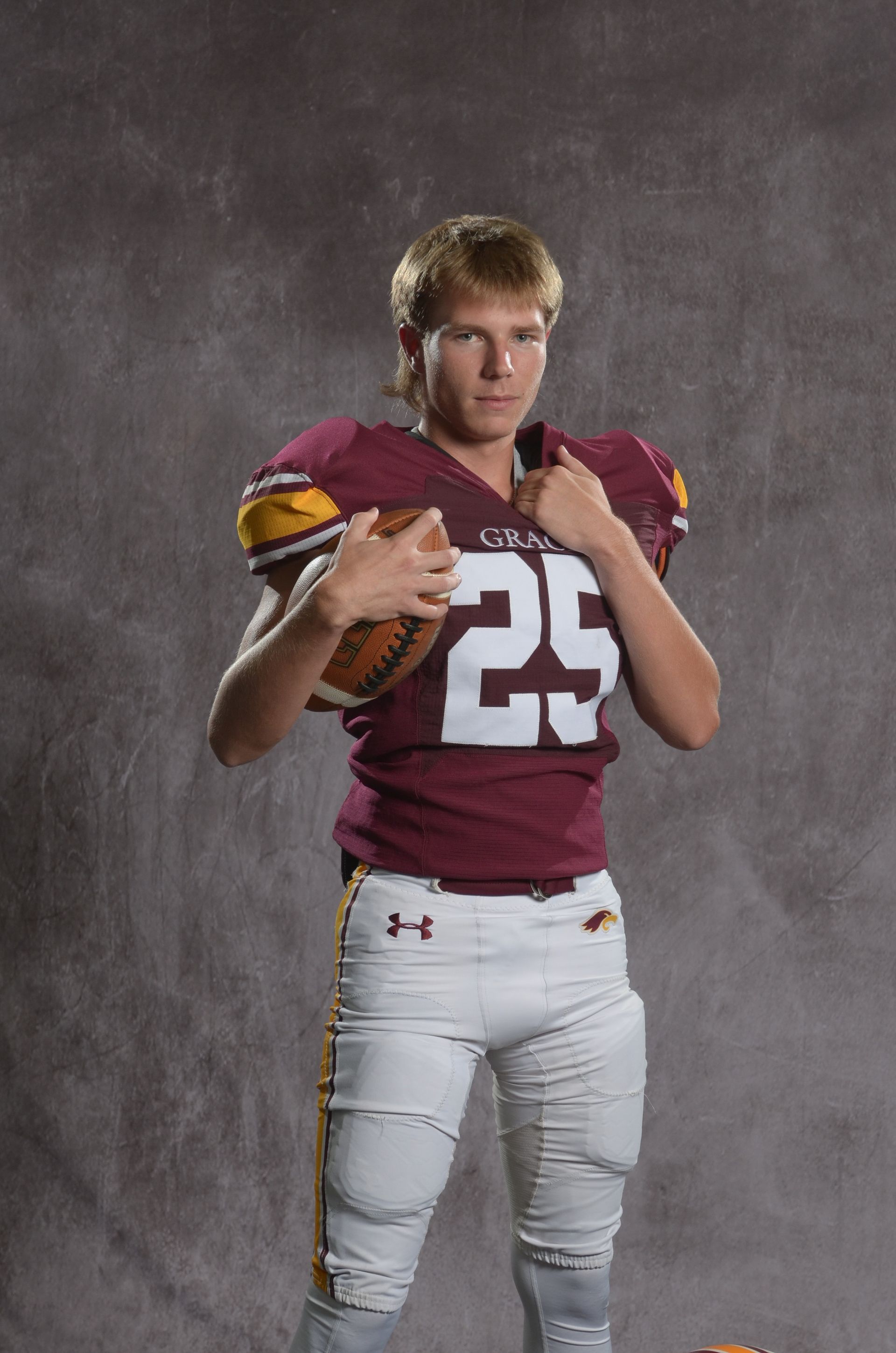 A maroon eagle head logo with a yellow beak on a white background.