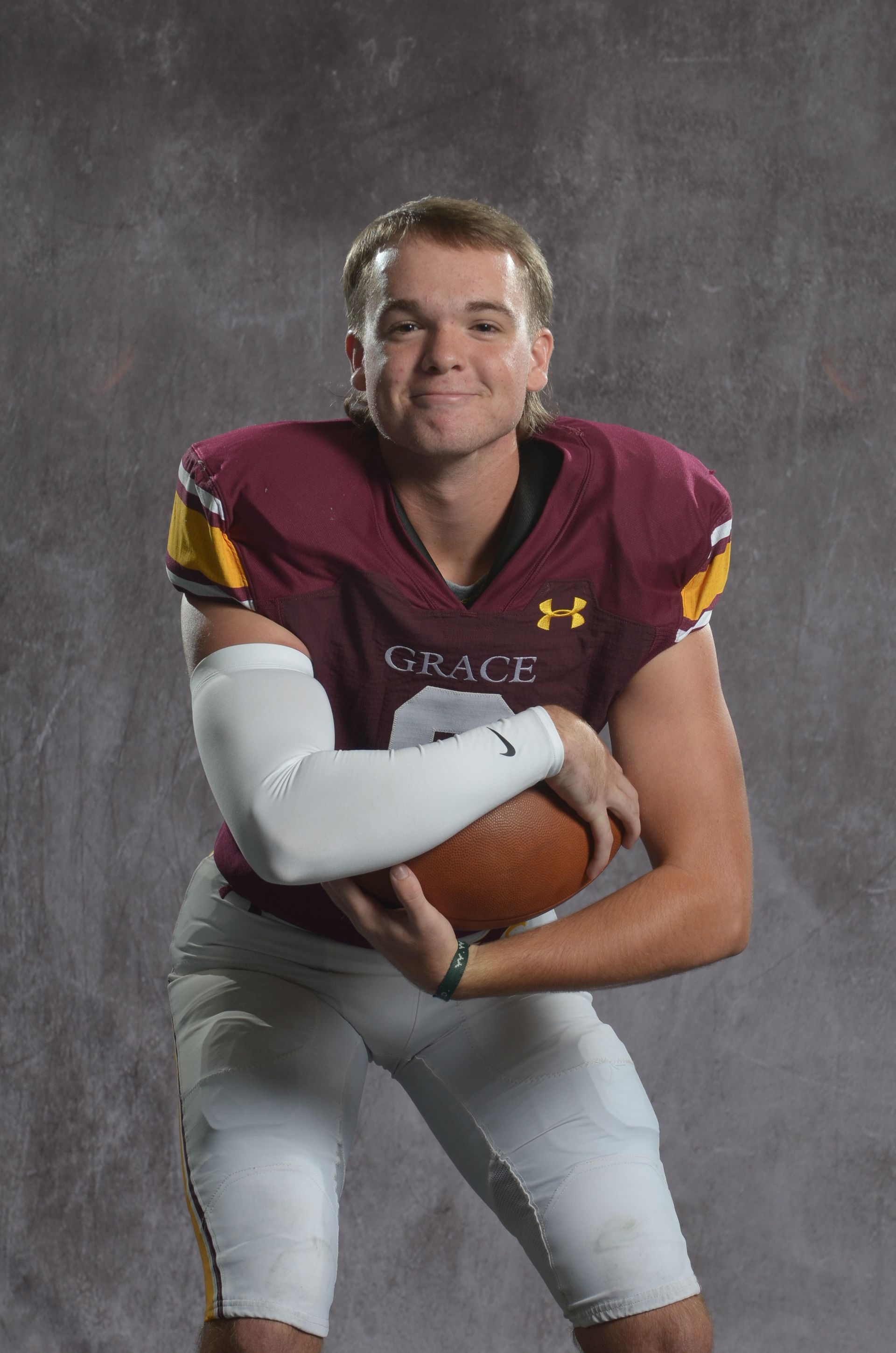 A maroon eagle head logo with a yellow beak on a white background.