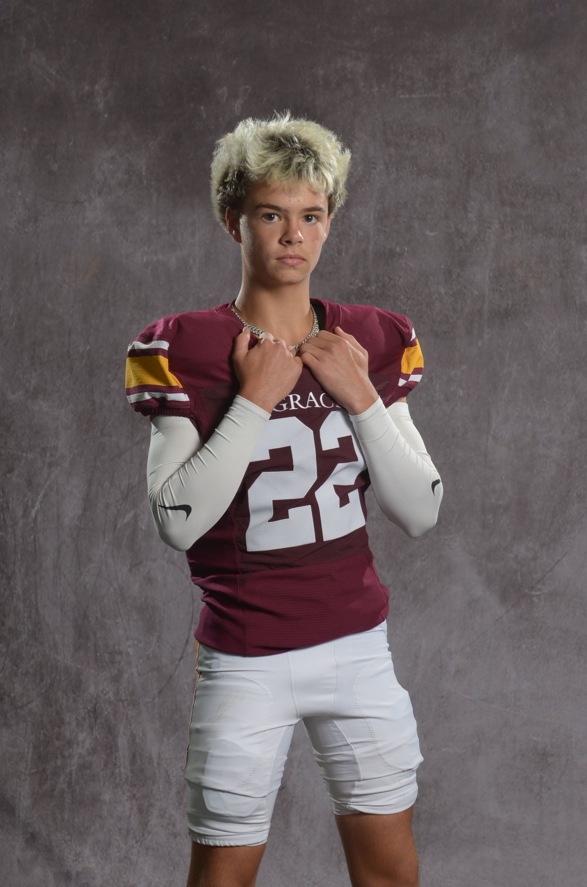 A maroon eagle head logo with a yellow beak on a white background.