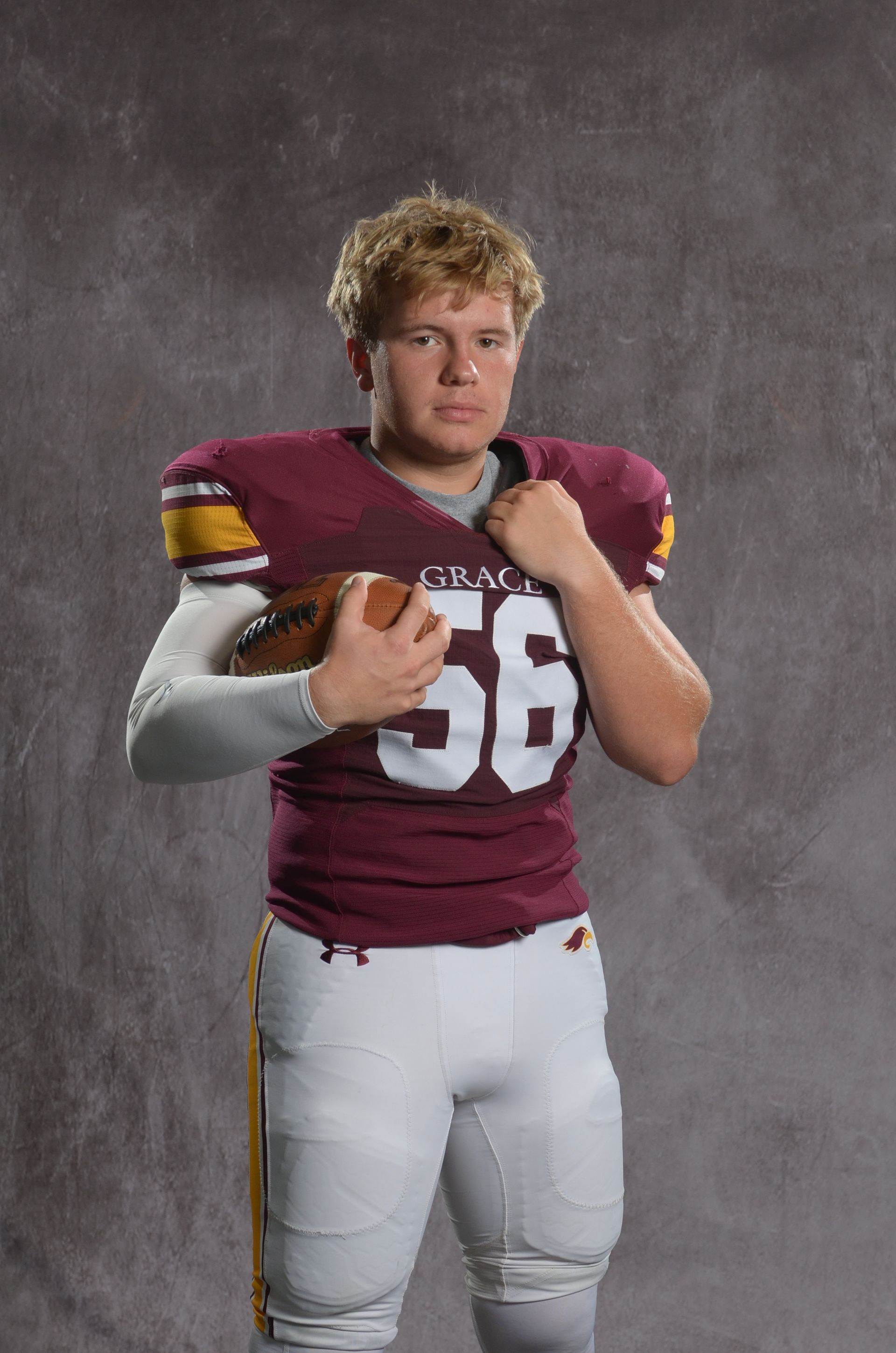 A maroon eagle head logo with a yellow beak on a white background.