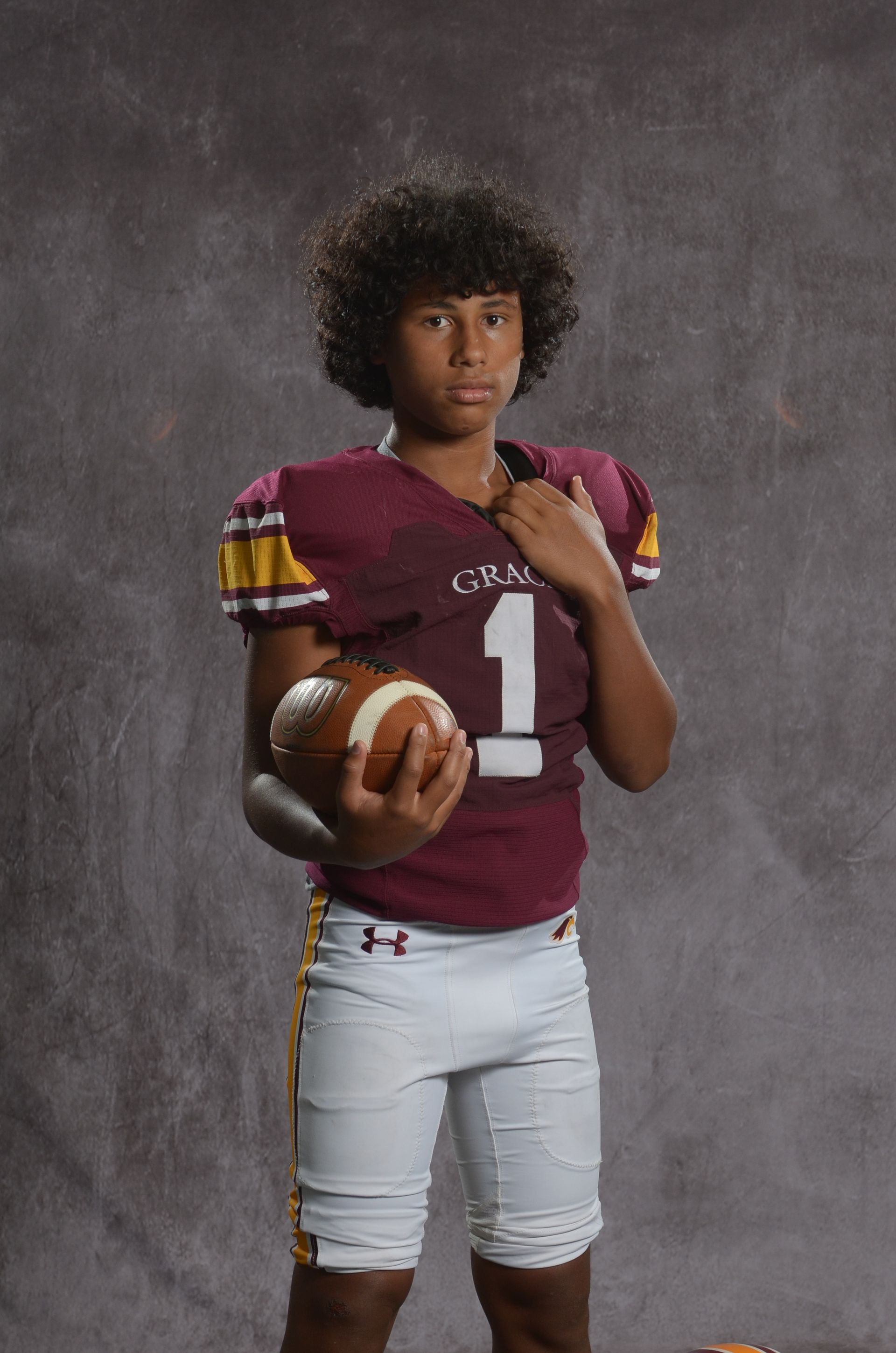 A maroon eagle head logo with a yellow beak on a white background.