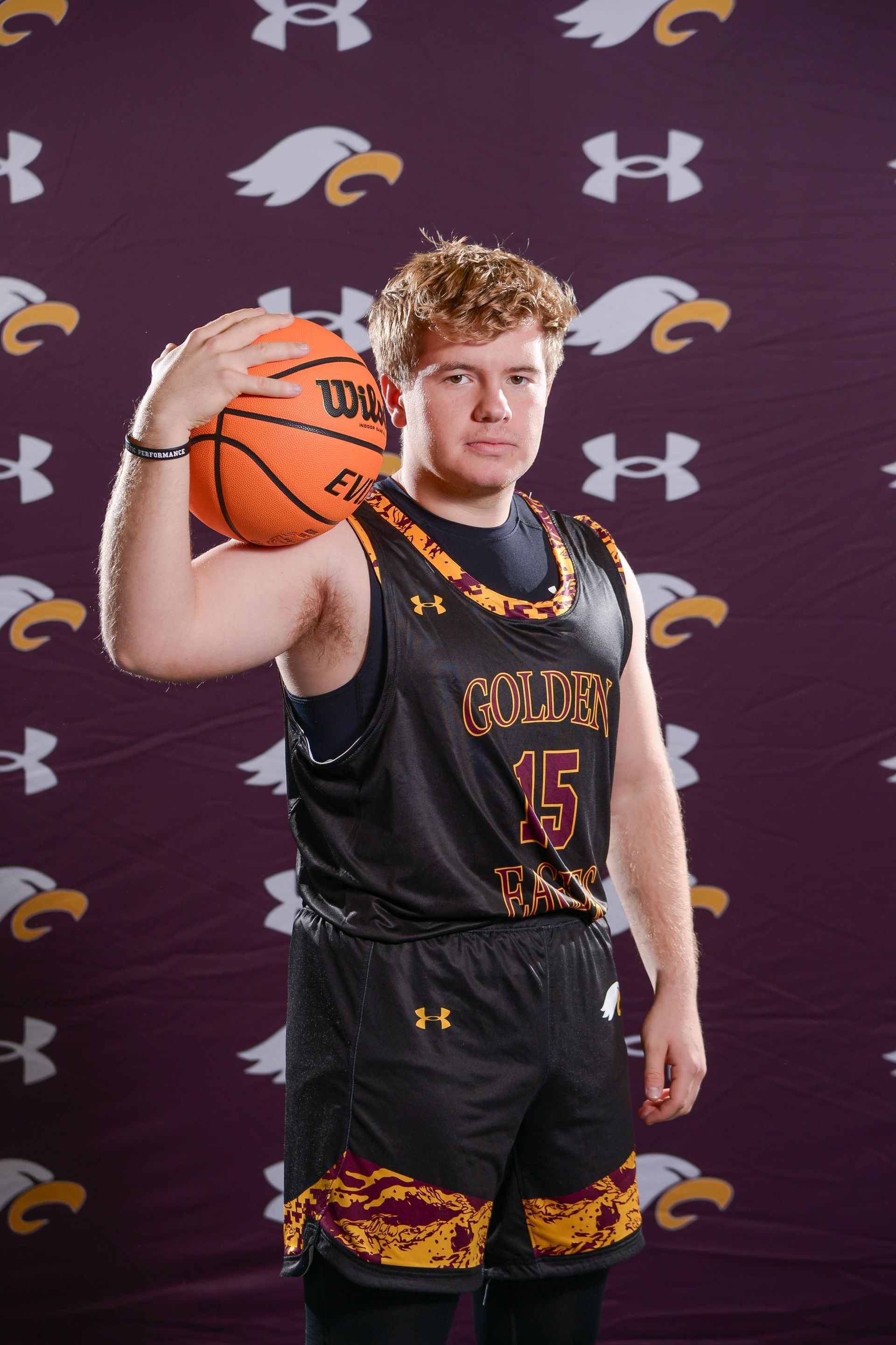 Basketball player in a Golden Eagles jersey, number 24, holding a ball and pointing, against a black background.