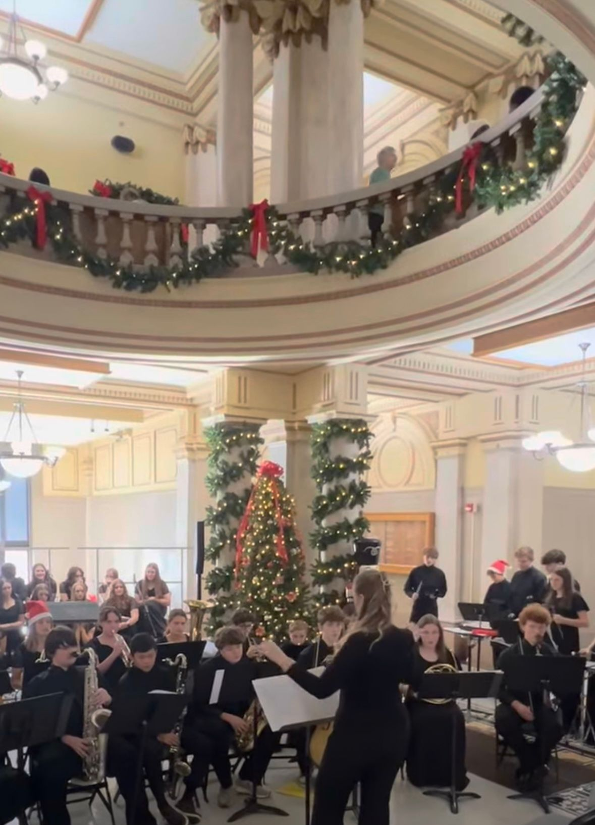 Three young women lying on grass, smiling, wearing casual clothes.