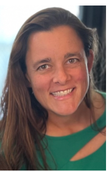 Woman with brown hair and a green shirt smiling at the camera.