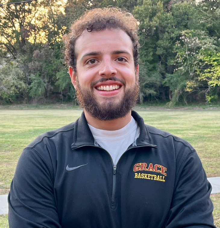Smiling man with a beard, wearing a black