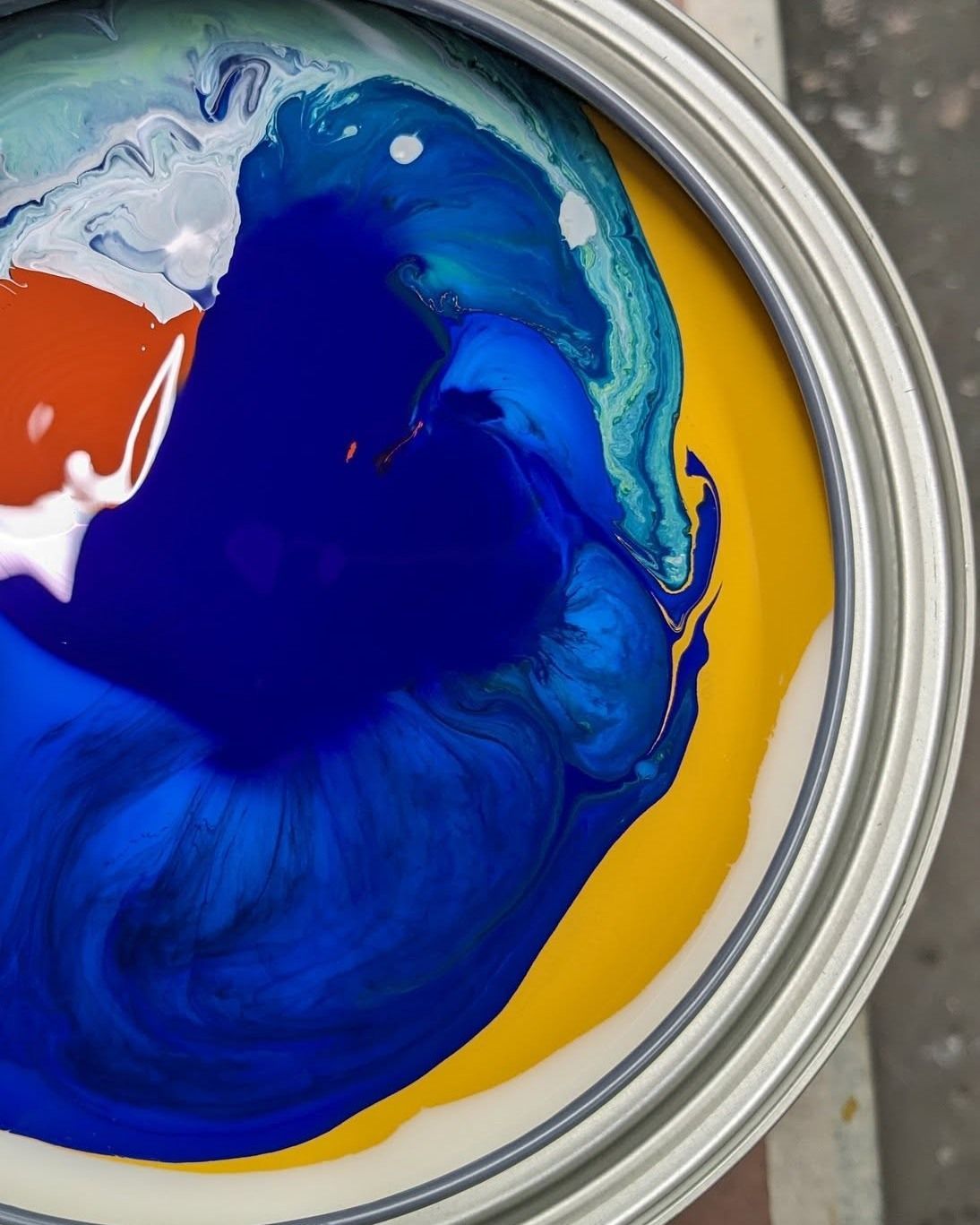 A close up of a can of blue and yellow paint