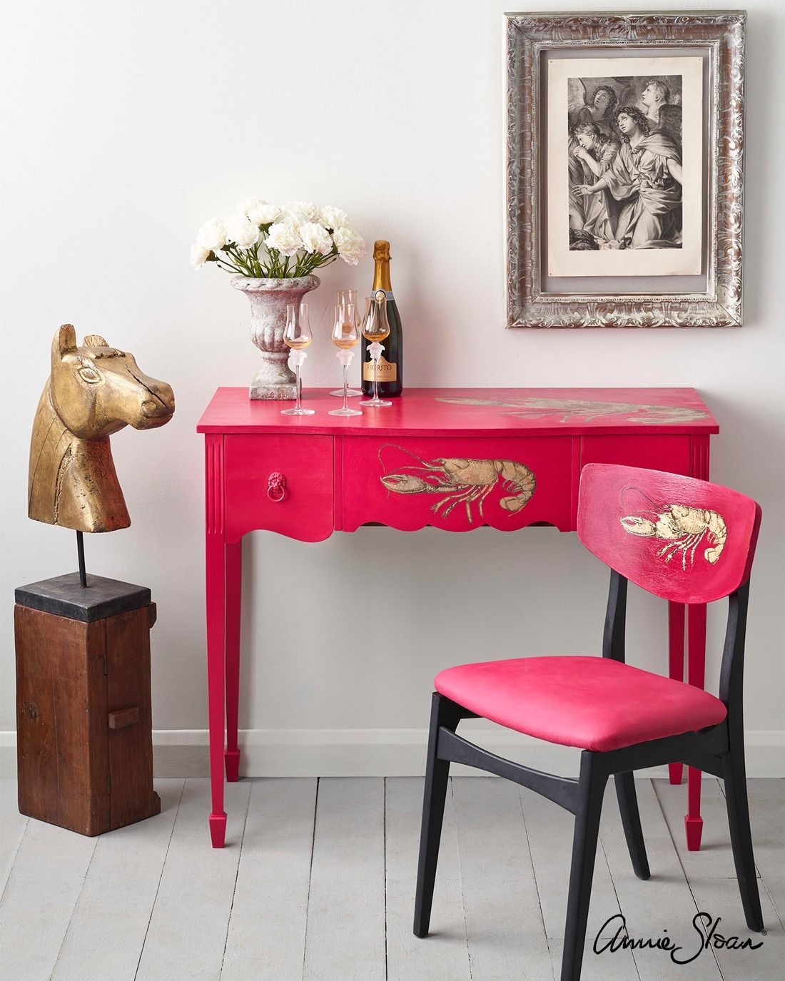 A pink desk with a chair and a picture on the wall