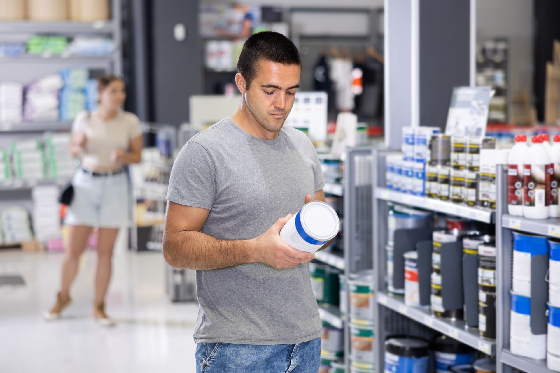 A man examines a product while shopping at one of his local professional paint stores. A man examines a product while shopping at one of his local professional paint stores.